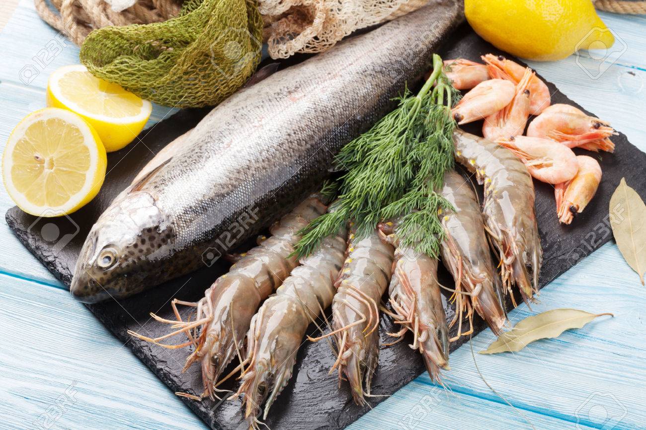 41226360-fresh-raw-sea-food-with-spices-on-stone-plate-over-wooden-table-background-top-view